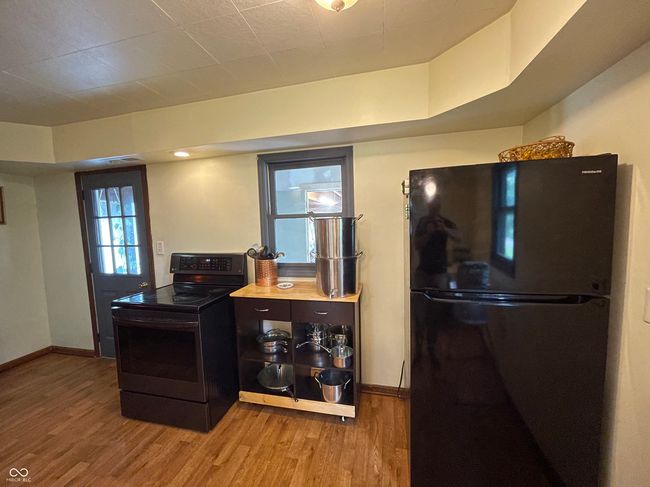 kitchen featuring black appliances and wood finished floors | Image 11