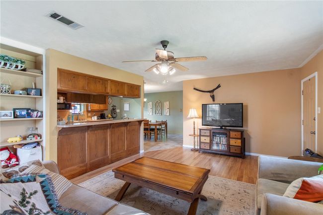 Living area with light wood-style floors and a ceiling fan | Image 15