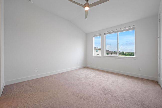 Empty room featuring ceiling fan, vaulted ceiling, and light carpet | Image 16