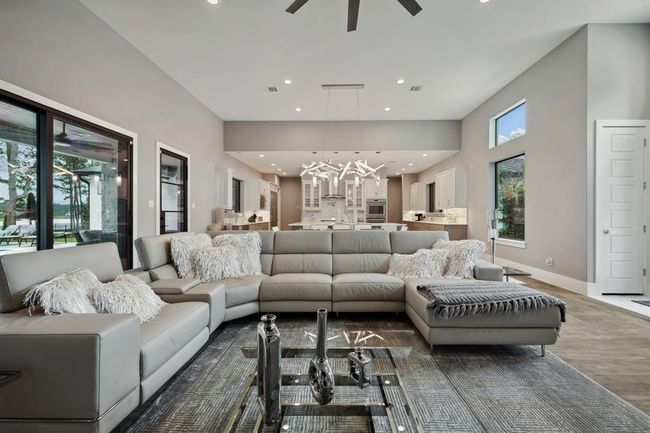 This inviting living room seamlessly flows into an expansive outdoor retreat, featuring a covered patio, a fully equipped outdoor kitchen, and a sparkling pool. | Image 20