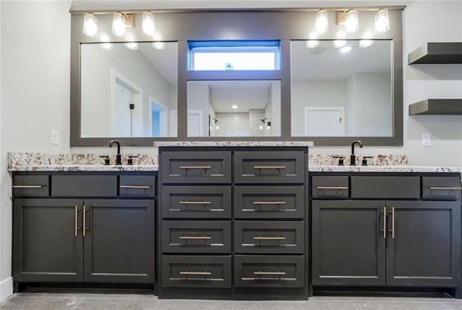 Full bath with double vanity, a tile shower, and tile patterned flooring | Image 12