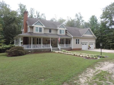 View of front of property featuring covered porch and a front yard | Image 1