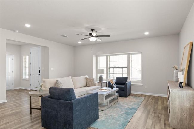 Living area with light wood-type flooring, recessed lighting, baseboards, visible vents, and a ceiling fan | Image 7