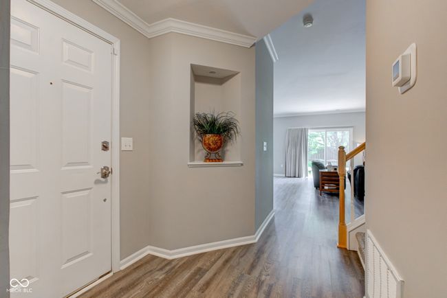 foyer with lamanite floors and crown molding | Image 6