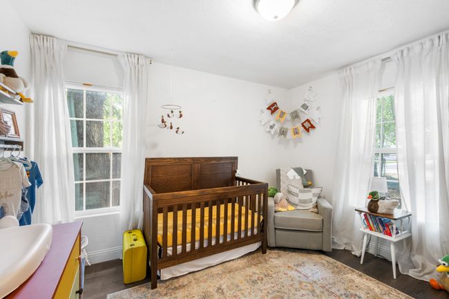 Bedroom with multiple windows, wood finished floors, and a nursery area | Image 19