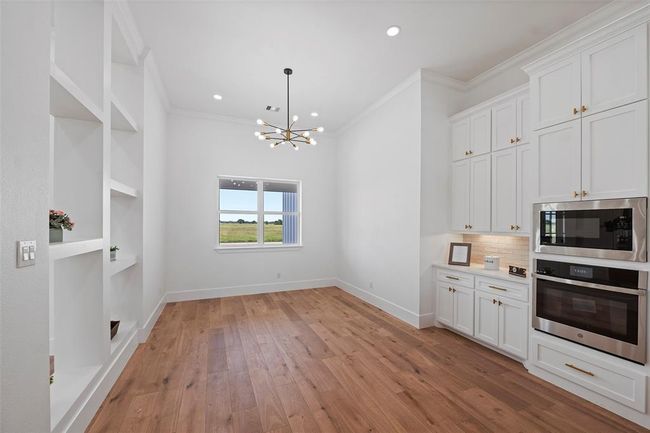 Elegant dining area featuring LVP floors, built-in shelving, and abundant natural light. Perfect for hosting gatherings or intimate meals with a view. | Image 10