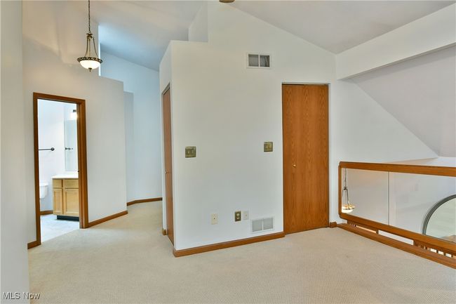 Carpeted empty room featuring vaulted ceiling and baseboards | Image 26