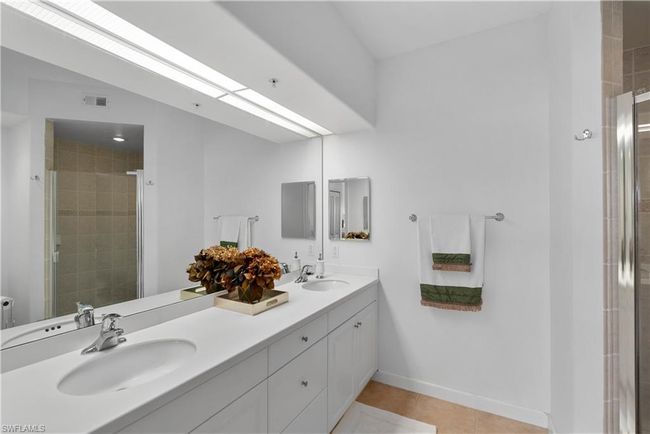 Main bathroom with a shower with door, tile patterned floors, and vanity | Image 11