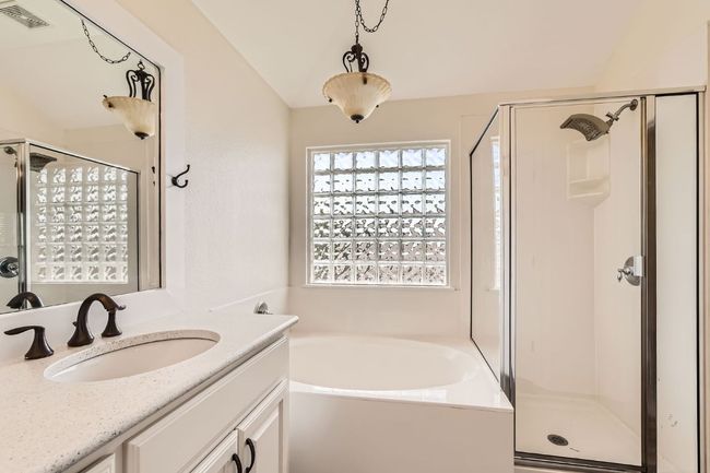 Bathroom featuring a shower stall, a garden tub, and vanity | Image 21