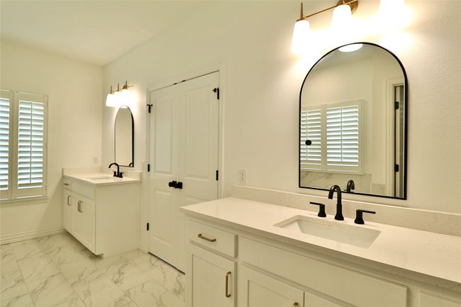 Bathroom featuring two vanities, marble finish floor, and a sink | Image 13