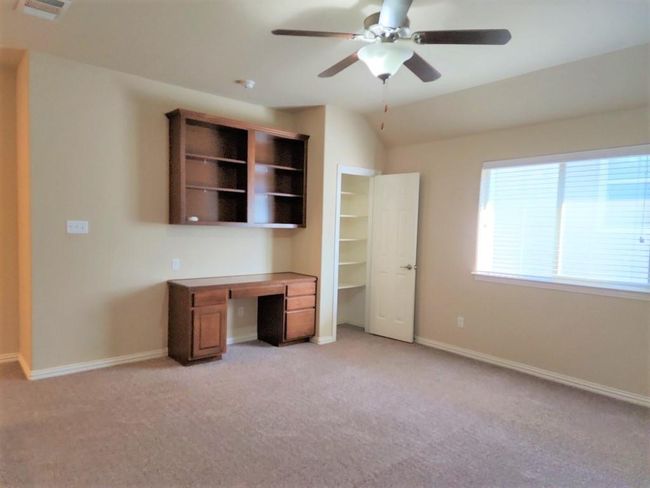 Unfurnished office featuring light carpet, a ceiling fan, and baseboards | Image 23