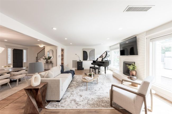 This living area features an open floor plan, a cozy fireplace, and ample natural light. | Image 13