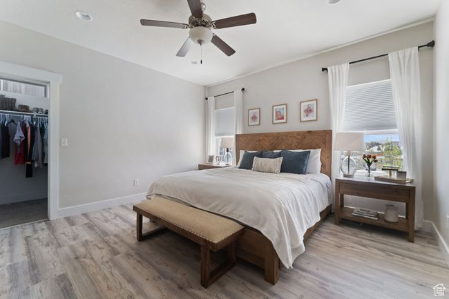 Bedroom with ceiling fan, baseboards, a spacious closet, and light wood-type flooring | Image 14