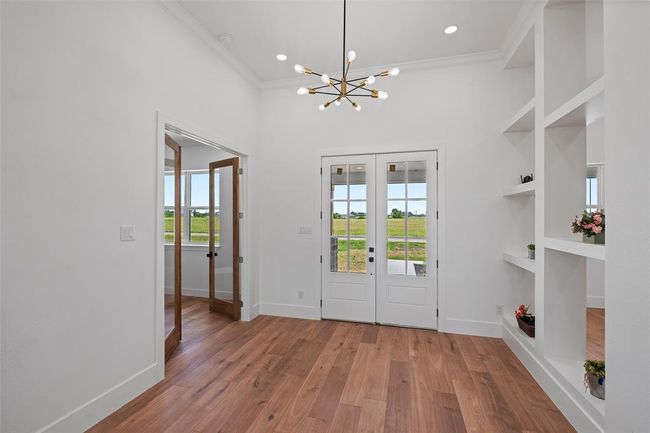Welcome home to a bright and stylish foyer, featuring elegant LVP floors, modern lighting, and built-in shelves for a welcoming first impression. | Image 5