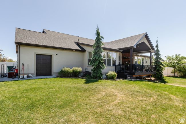 View of front of house featuring a front yard, a deck, roof with shingles, stucco siding, and a garage | Image 48