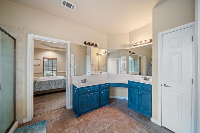 Bathroom with double vanity, a sink, a shower stall, and visible vents | Image 22