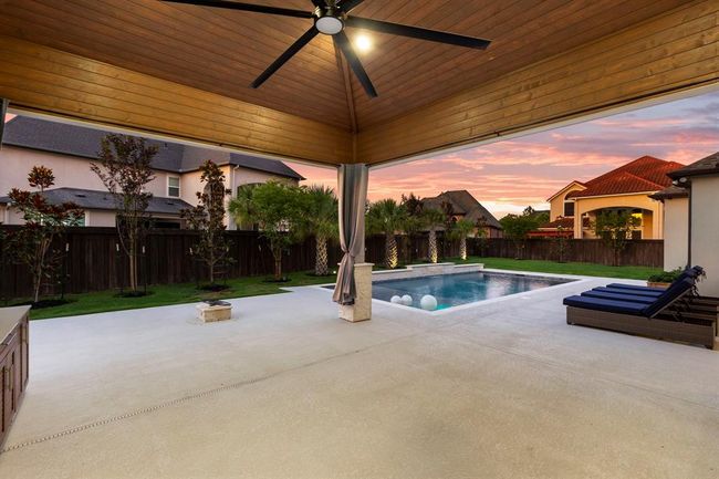This extended outdoor living features a wood-paneled ceiling, built-in gas firepit outlet, and seamless access to the pool—perfect for year-round entertaining and relaxing. | Image 43