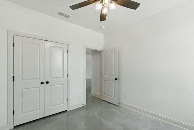 Unfurnished bedroom featuring concrete floors, a closet, baseboards, and a ceiling fan | Image 21