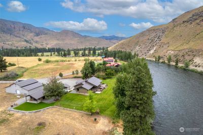 Stunning, private oasis on the Methow River built for entertaining! 10.50 acres with 1200+’ of riverfront and a newly remodeled home. Main house: 3 BD, 2 BA with high-quality finishes, huge primary suite, large deck, and gourmet kitchen with imported Italian range. Large windows capture river views. Guest house: 2 BD, 1 BA, large flex space for bunk room, office, rec room, or studio. Shop with two 14’ doors for RV access plus heated, finished workshop space. Second parcel has well and septic in place. Exceptional attention to detail inside and out. Conveniently located between Mazama and Lake Chelan. | Image 1