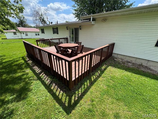 Wooden deck with a lawn and outdoor dining area | Image 9