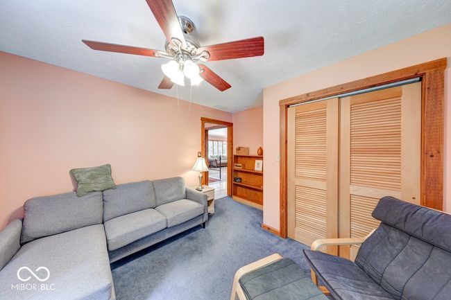 living area featuring a ceiling fan and carpet floors | Image 33