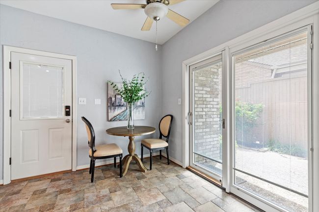 Dining area featuring light stone finish floors, healthy amount of natural light, baseboards, and ceiling fan | Image 12