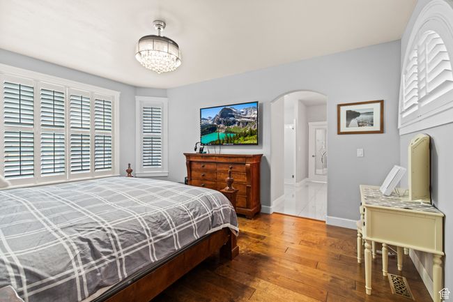 Bedroom featuring hardwood / wood-style floors, a chandelier, and multiple windows | Image 44