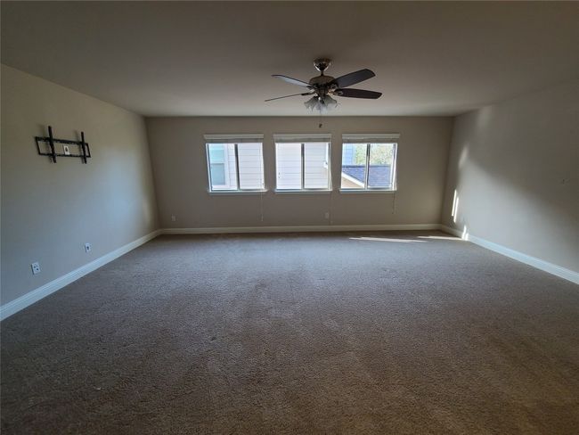 Unfurnished room featuring dark colored carpet and ceiling fan | Image 29