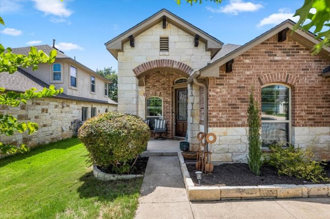 French provincial home featuring stone siding, brick siding, and a front lawn | Image 4