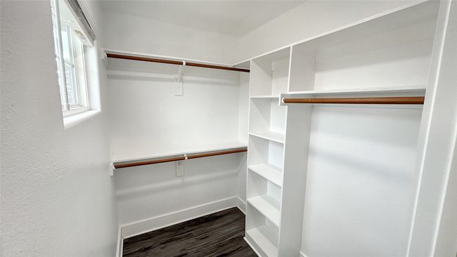 Walk in closet featuring dark wood-style flooring | Image 10