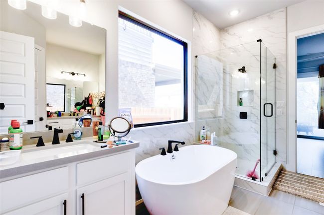 Full bath featuring tile walls, a marble finish shower, a freestanding tub, and vanity | Image 21