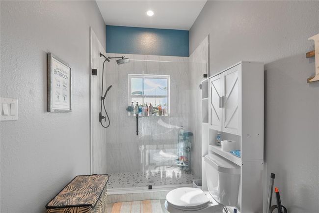 Luxurious primary bathroom shower with sleek glass doors and modern fixtures. | Image 12