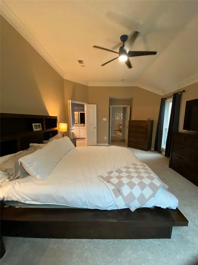 Bedroom featuring carpet, visible vents, ceiling fan, lofted ceiling, and ornamental molding | Image 20