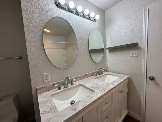 Bathroom featuring double vanity and a textured wall | Image 34