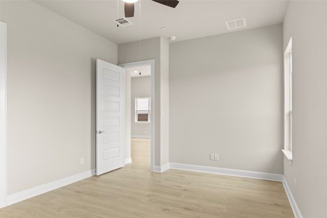 Empty room featuring attic access, light wood-type flooring, ceiling fan, and baseboards | Image 25