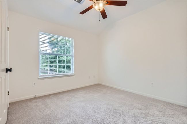 Spare room with ceiling fan, light colored carpet, baseboards, and lofted ceiling | Image 28