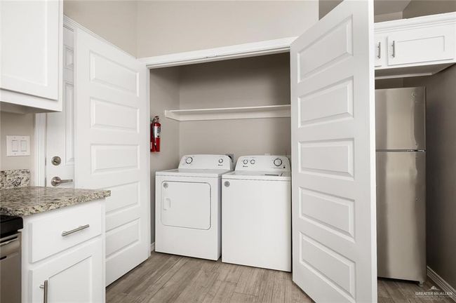 Laundry room featuring light wood-style floors and washer and clothes dryer | Image 9