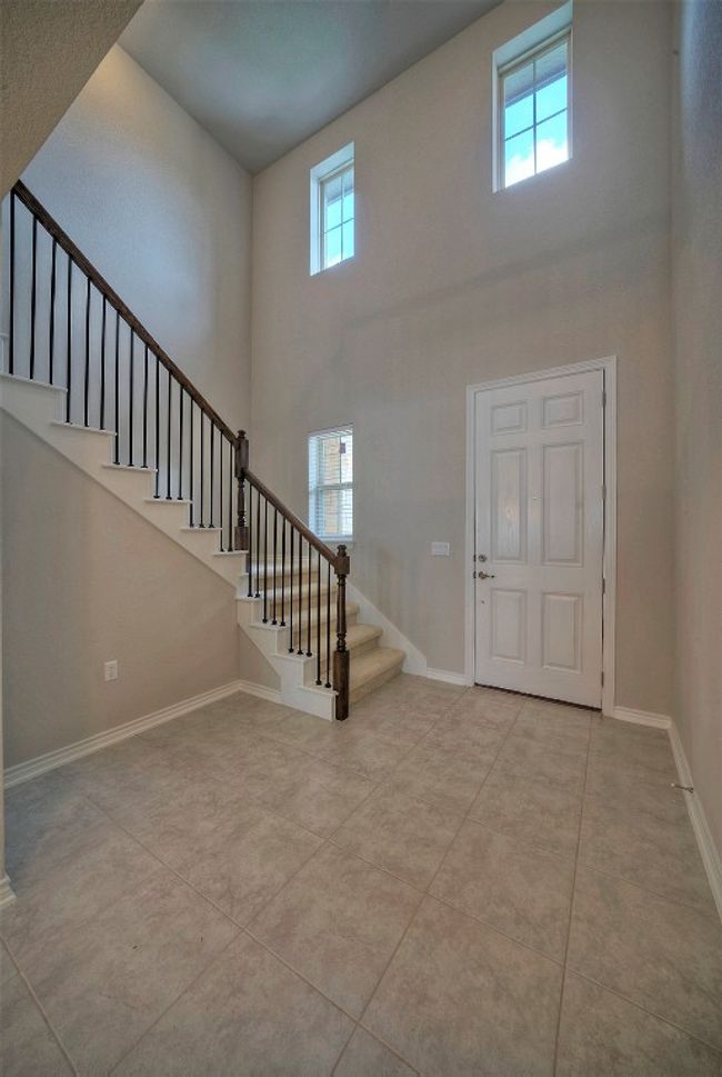 Tiled foyer with baseboards, stairs, a wealth of natural light, and a towering ceiling | Image 6