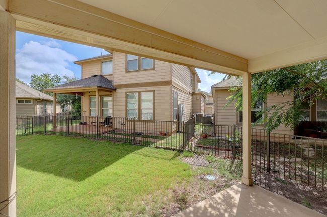 The covered back porch and fenced yard provide the perfect setting for relaxing outdoors, hosting BBQs, and play. | Image 26