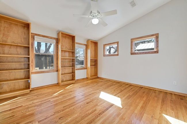 Unfurnished room with light wood-type flooring, visible vents, baseboards, ceiling fan, and vaulted ceiling | Image 15
