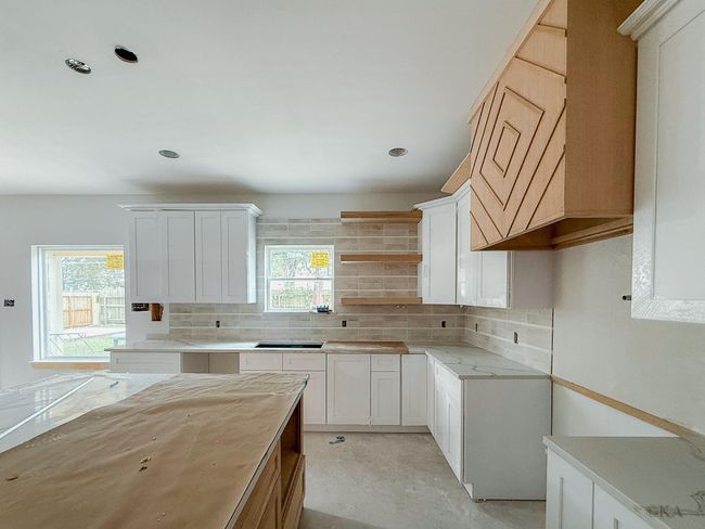 This gourmet kitchen will feature Bosch appliances with a 36-inch range, custom designed vent hood, pot filler, new island pendant lighting, dishwasher, and drawer microwave. | Image 10