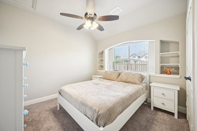 Carpeted bedroom featuring visible vents, baseboards, ceiling fan, and vaulted ceiling | Image 19