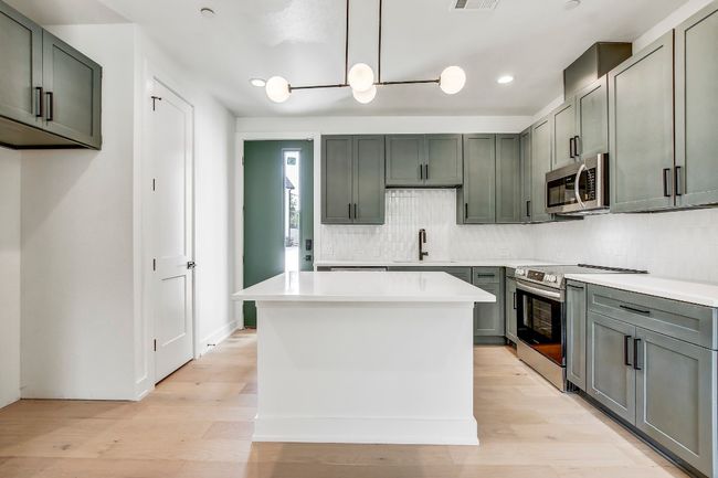 Kitchen featuring appliances with stainless steel finishes, a sink, tasteful backsplash, light countertops, and recessed lighting | Image 10