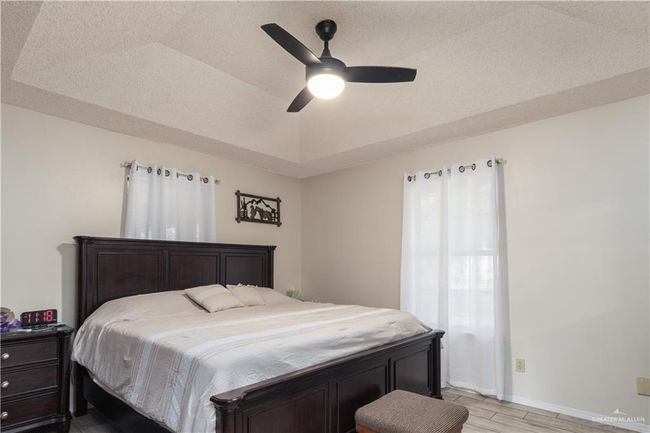 Bedroom with light wood-style flooring, baseboards, and a ceiling fan | Image 10
