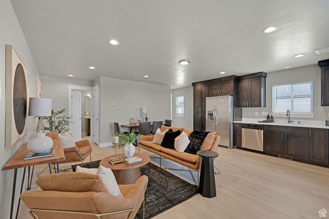 Living area with light wood finished floors, recessed lighting, and a textured ceiling | Image 5