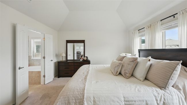 Bedroom featuring multiple windows, light carpet, and vaulted ceiling | Image 24