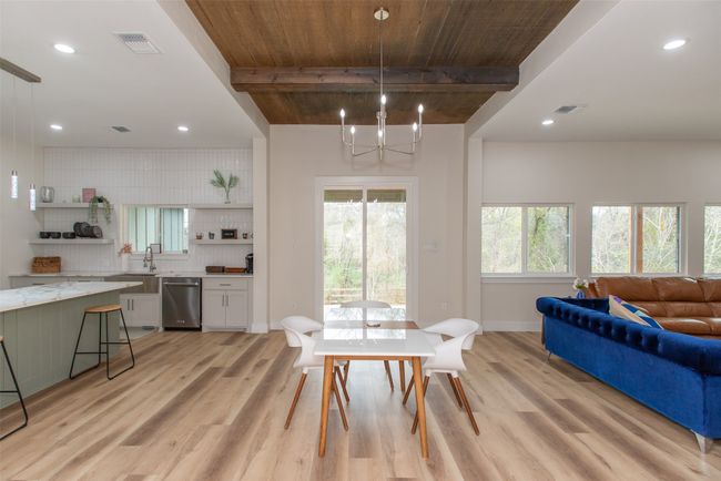Dining area featuring beam ceiling, sink, wooden ceiling, an inviting chandelier, and light hardwood / wood-style flooring | Image 14