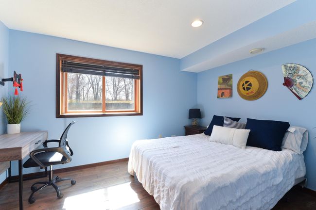 Lower level bedroom offers a secret closet behind the shelves | Image 21