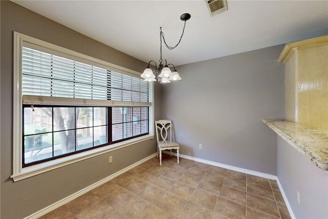 Dining area featuring a chandelier, baseboards, and tile patterned flooring | Image 9