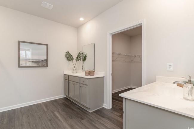 Bathroom featuring two vanities, wood finished floors, a spacious closet, and recessed lighting | Image 18